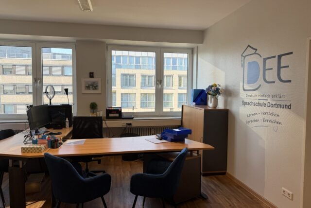 Beratungsraum der DEE-Sprachschule mit Logo an der Wand