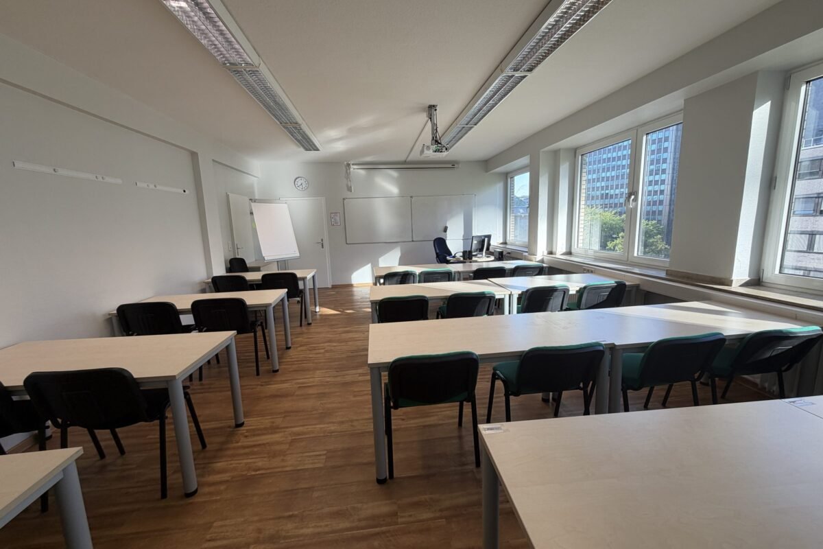 Kursraum mit Flipchart und Tischen für Gruppenarbeit